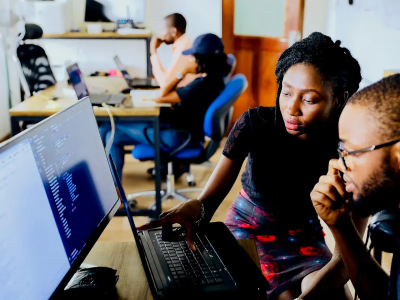 Two engineers pair-programming at a laptop
